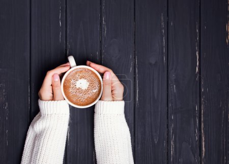 女人的双手捧着杯咖啡的毛衣