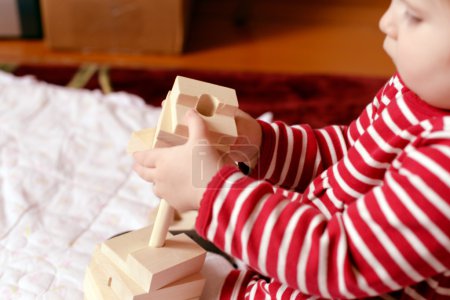 Baby playing with simple wooden toys