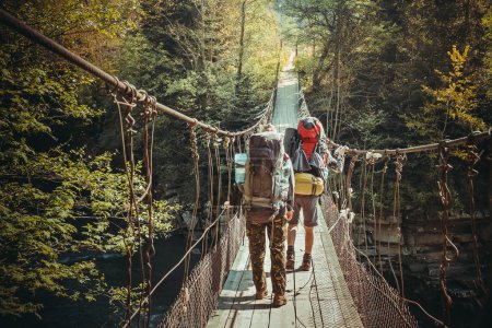 Travelers crossing through hanging bridge 