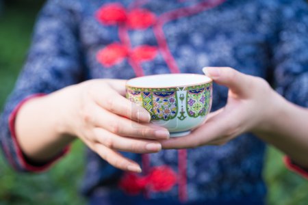 亚洲女孩在茶园中保存杯