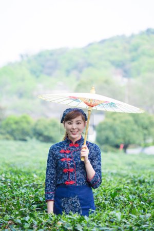 亚洲女孩拿着雨伞在茶园