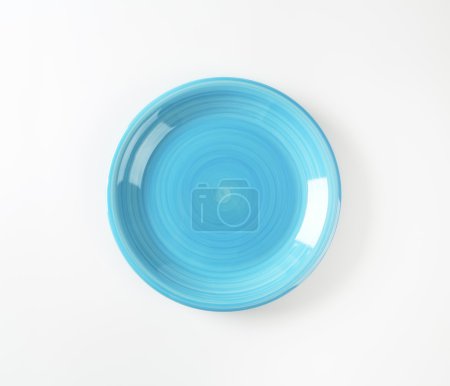 Rimless round blue ceramic plate