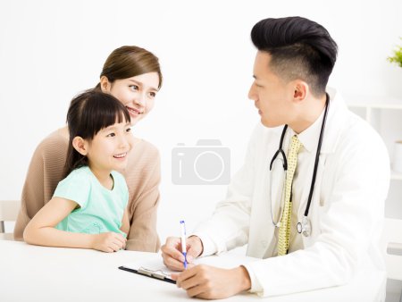 young doctor talking to young child and mother