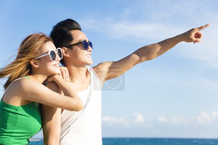 Happy young Couple looking at view on the Beach