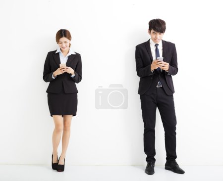 年轻的商界男人和女人拿着智能手机 