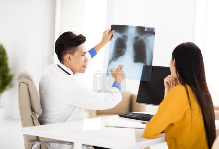  young doctor looking at patient's x-ray film