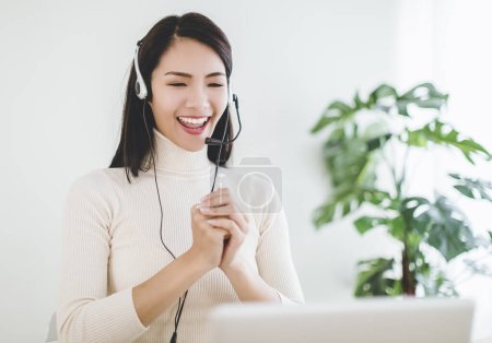 Happy asian young woman  making distance video call with congratulations gesture for chinese new year