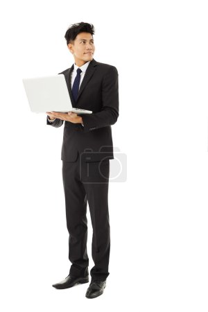 抱着笔记本电脑的年轻男人微笑着业务