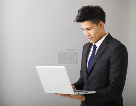 使用笔记本电脑的年轻男人微笑着业务
