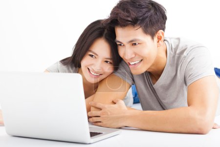 看着笔记本电脑对年轻快乐夫妇