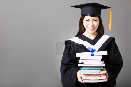 Beautiful young graduate holding diploma and book