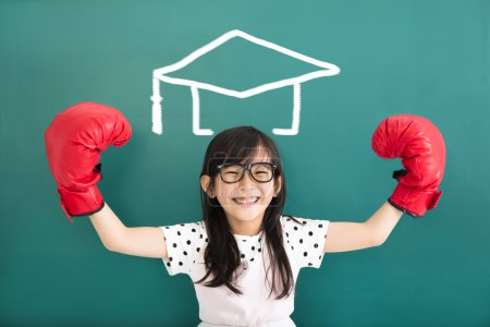 Happy little girl with boxing gloves and graduation concept