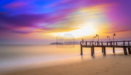 Long exposure of colorful sunrise and wooden pier