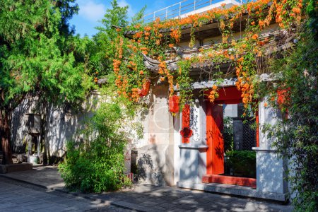 Gate of traditional Chinese house decorated with flowers, Dali