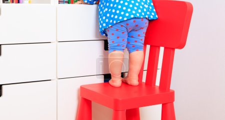 kids safety - little girl climbing on baby chair