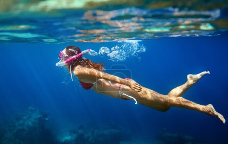 在热带海洋水下游泳的女人 