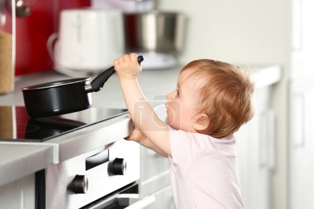 Little child playing with pan 