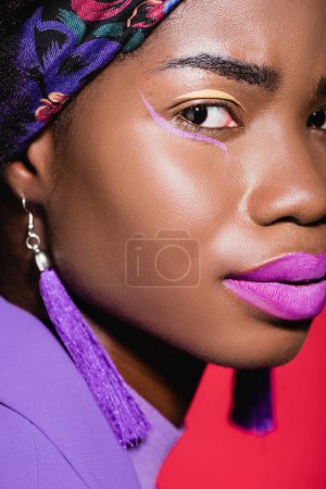 非洲裔美国年轻女子的特写镜头，身穿紫色时髦服装，与红色隔离
