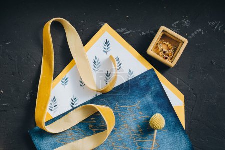 Yellow envelope and invitation on blue paper