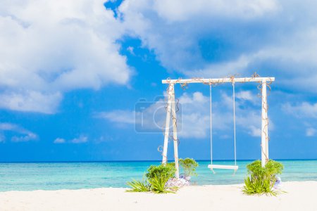 Wedding arch decorated with flowers on tropical sand beach, outd