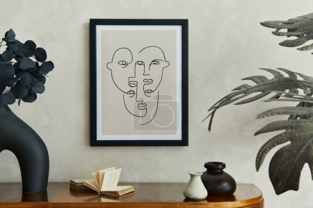 创意客厅室内装饰风格别致的构图，附有模型海报框、木制堆芯、棕榈叶、设计花瓶中的黑色干叶和典雅的个人配饰。中性米色墙。模板.
