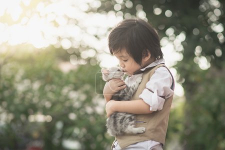 Asian boy  holding american short hair  kitten 