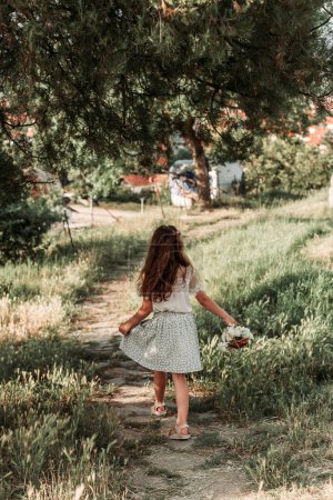 Little girl walking with a basket of flowers