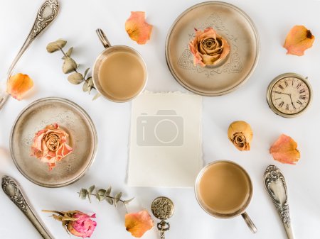 Two cups of coffee with roses and empty card. Flat lay. Top view