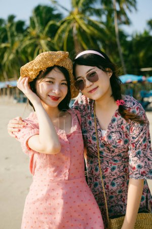 两个女孩在海滩上一起欣赏的肖像.