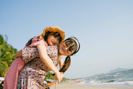 在阳光明媚的日子里，戴着太阳镜的女孩背着她的朋友在海滩上散步.