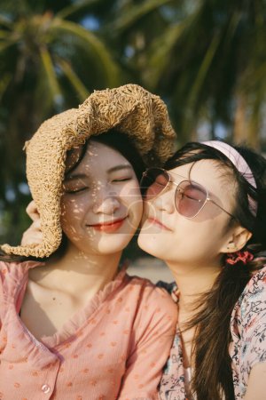 2.两个女孩在黄昏的阳光下坐在沙滩上.