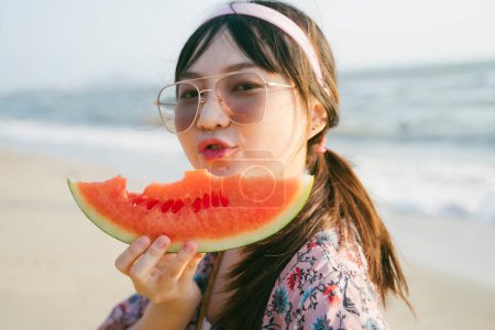 戴着太阳镜，拿着西瓜做鸭脸的女孩.