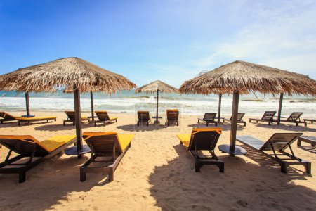 Sun umbrella and sun loungers stand at the beach in Phuket, Thai