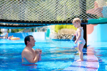 Father and daughter playing in swimming pool