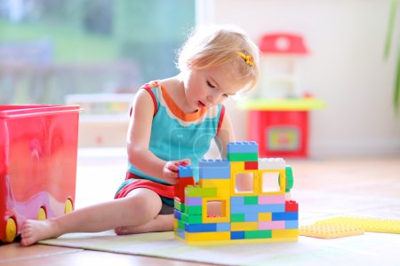 Little girl playing with construction blocks