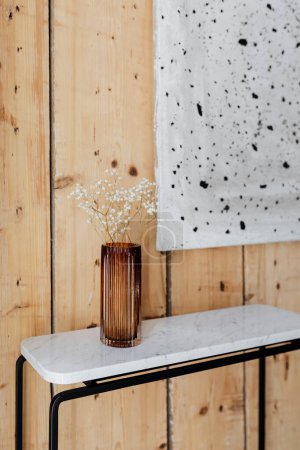 木制墙壁上的一个艺术品旁边的大理石桌子