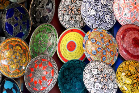 Traditional colorful Moroccan faience pottery dishes in a typical ancient shop in the Medina's souk of Marrakech, Morocco.