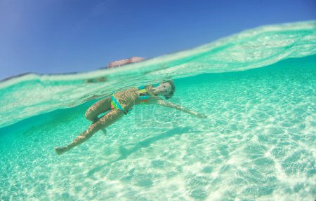 Beautiful young women in dress diving in ocean near Maldives islands