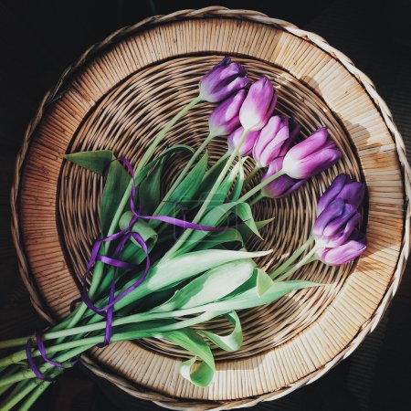 Purple tulips on wicker basket