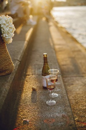 夕阳照亮了海滨的石阶和白葡萄酒酒杯