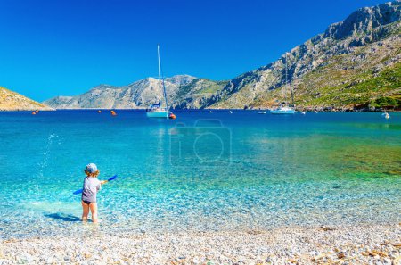 Sea bay on Greek Island with small boy at play