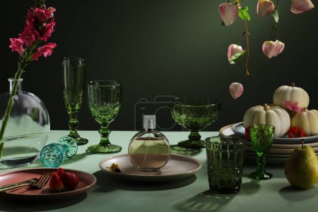 漂亮的餐桌，用绿色和迷你南瓜装饰在盘子里，花束插在高高的花瓶里，还有瓷盘和绿色眼镜.