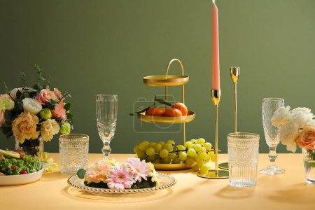 婚宴桌上摆设，白盘，玻璃杯，点缀蜡烛，绿叶，花朵，层次分明的托盘，水果.
