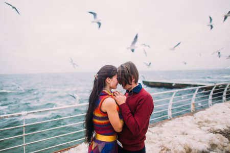 Lovers on the pier and seagulls at background. Romantic honeymoon