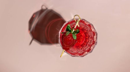 Glass of rose champagne with a strawberry on pink pastel background. Creative flat lay with copy space