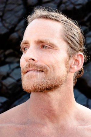 handsome man gazing into the distance with   gentle smile of