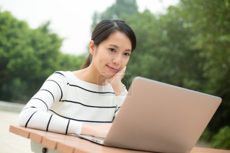 Woman working on laptop at outdoor cafe