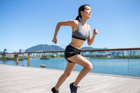 Woman running on seaside boardwalk