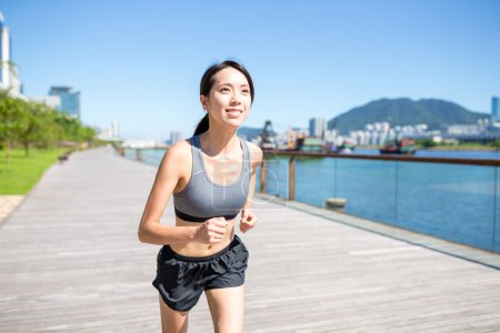 Woman running on seaside boardwalk