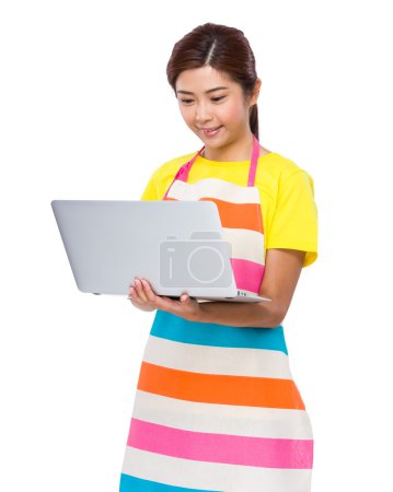 Woman in apron using laptop
